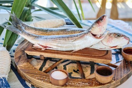Photo for A photo showcasing two fish sitting on top of a wooden tray. - Royalty Free Image