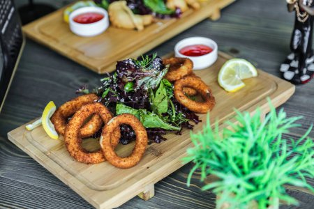 A table filled with various dishes featuring onion rings as a delicious topping.