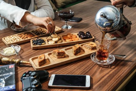 Photo for A wooden table is adorned with an array of trays filled with delectable food. - Royalty Free Image