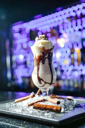 A decadent chocolate milkshake topped with creamy whipped cream and drizzled with rich chocolate sauce.