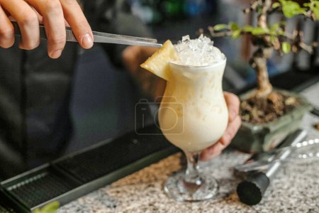 A person holds a knife threateningly above a drink, showing a potential act of aggression.