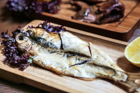 Téléchargez les photos : Vue détaillée d'un poisson récemment préparé sur une planche à découper en bois. - en image libre de droit