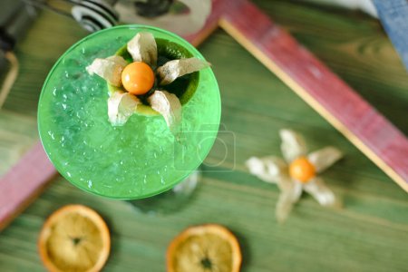 A detailed close-up view of a refreshing green drink with slices of oranges floating on top.