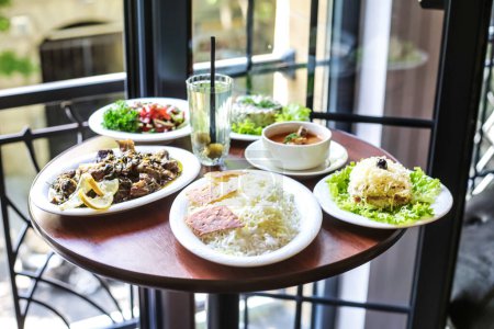 Une table en bois présentant une variété de plats, y compris des assiettes d'entrées, des plats principaux et des desserts.