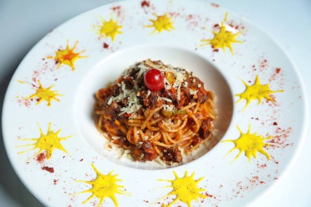 A white plate is presented with a generous serving of spaghetti and sauce, creating a delicious and appetizing meal.