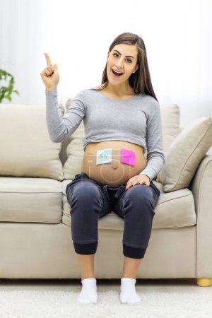 Photo for VPhoto of positive pregnant woman with pink and blue papers on the stomach which mean gender of future baby. Concept of pregnant woman. - Royalty Free Image