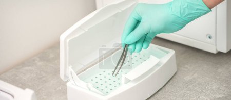 Photo for Hand disinfects tweezers with cleaning systems for medical instruments. Ultrasonic cleaner - Royalty Free Image