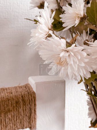 Téléchargez les photos : Photo de belles fleurs de chrysanthème blanc délicat avec des feuilles vertes sur un fond blanc - en image libre de droit