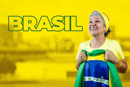 Téléchargez les photos : Belle femme âgée tenant le drapeau du Brésil sur fond cinématographique. Pour les médias sociaux avec espace de copie. - en image libre de droit