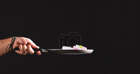 Photo for Making Brazilian-style Ceviche on Black Background. Frying Pan Throwing Ingredients Like Red Onion, Cheese, Basil and Seasonings Into the Air. - Royalty Free Image