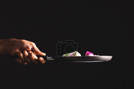 Photo for Making Brazilian-style Ceviche on Black Background. Frying Pan Throwing Ingredients Like Red Onion, Cheese, Basil and Seasonings Into the Air. - Royalty Free Image