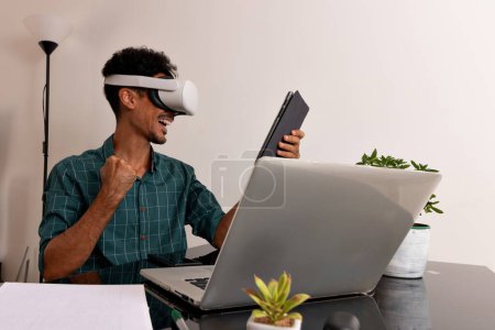 Black Man Wearing VR Glasses at Remote Job. Young Nomad on a Teleworking Meeting at Desk With Laptop