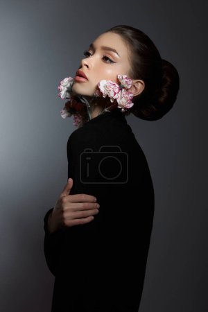 Téléchargez les photos : Beauté éthérique femme en noir avec ornement floral regardant vers le haut dans une élégance profonde - en image libre de droit