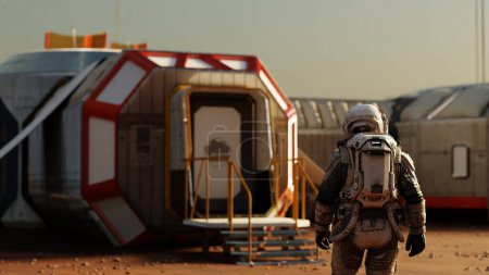 Téléchargez les photos : L'astronaute se tient devant l'entrée d'un habitat modulaire sur Mars, le début d'une nouvelle ère. 3d rendu - en image libre de droit