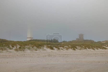 Leuchtturm und Bunker in den Sanddünen am Strand von Blavand im Nebel, Jütland Dänemark Europa