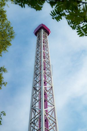 Ride tower in amusement park on blue sky background.