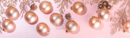 Rose gold Christmas, New Year background with golden christmas tree twigs and balls, holiday gift boxes, decorations, artifical snow, flat lay on pink background copy space Poster 620400726
