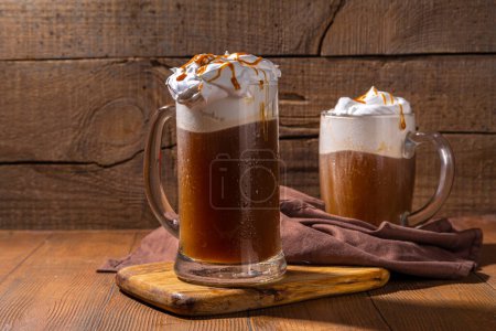 Photo for Sweet Homemade Butterscotch Butter Beer, non-alcohol beer styled caramel autumn winter drink, with whipped cream - Royalty Free Image