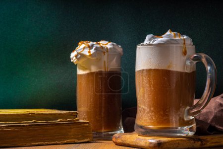 Photo for Sweet Homemade Butterscotch Butter Beer, non-alcohol beer styled caramel autumn winter drink, with whipped cream - Royalty Free Image