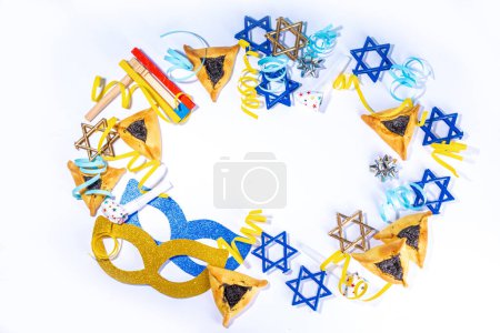 Téléchargez les photos : Jewish holiday Purim greeting card background, jewish spring start holiday carnival flat lay with traditional carnival masks, rattle, gifts and hamantaschen cookie on white background - en image libre de droit