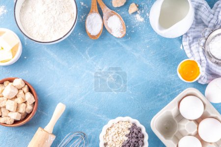 Photo for Baking ingredients background. Cooking ingredients (flour, eggs, milk, brown sugar, butter) with utensils on light blue background top view copy space - Royalty Free Image