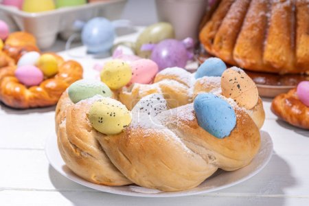 Pan de corona de Pascua, horneado tradicional de vacaciones de Pascua, pasteles de bollo dulce con coloridos huevos de Pascua, en el espacio de copia de mesa decorada fiesta de brunch
