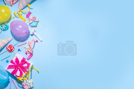 Photo for Happy birthday greeting card background. Flatlay with colorful holiday tools - birthday party caps, blowers, gift boxes , balloons, steamers, candles, on blue background copy space - Royalty Free Image
