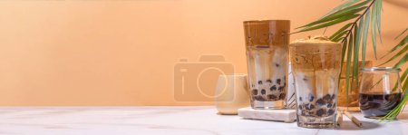 Téléchargez les photos : Café Boba dalgona. Tendance asiatique latte matin boisson avec café instantané fouetté et boules de perles de tapioca, été thai bulle verre à cocktail en arrière-plan ensoleillé - en image libre de droit