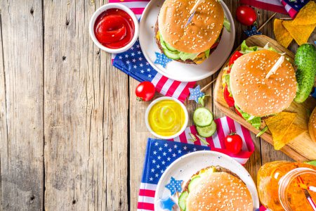 Feierlichkeiten zum Unabhängigkeitstag, 4. Juli. Traditioneller amerikanischer Gedenktag Patriotisches Picknick mit Burgern, Pommes und Snacks, Sommer-Picknick in den USA und BBQ-Konzept, Alter Holzhintergrund 
