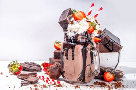 Photo for Double chocolate taste milkshake. Crazy shake with brownie taste, chocolate sauce, whipped cream topping and fresh strawberry, summer sweet loaded sweet dessert drink copy space - Royalty Free Image