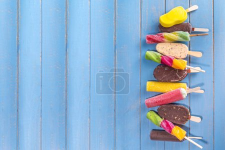 Photo for Various ice cream popsicle on turquoise wooden background, summer sweets, dessert, vacation and holiday background, Set of assorted flavors popsicle lollipops - chocolate, vanilla, fruit, rainbow - Royalty Free Image