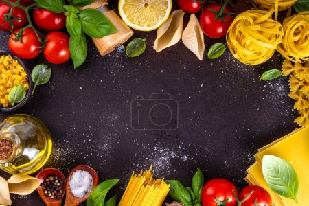 Various pasta with spices and ingredients for cooking. Preparation dinner, lunch background with fresh basil, tomatoes, spices, garlic and different sort and types of italian Mediterranean pasta