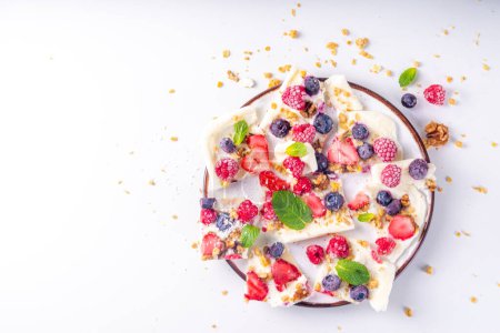 Photo for Homemade frozen Yogurt Bark, alternative healthy keto diet ice cream made from greek yogurt, fresh berries, nuts, granola, honey, on baking tray deco. Frozen yoghurt bars with fruit berry toppings - Royalty Free Image