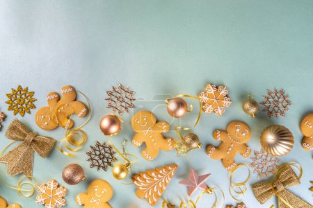 Photo for Christmas Gingerbread cookie background. Various festive biscuits - Gingerbread man, snowflakes, Christmas tree - with Xmas, New Year, Noel golden decoration on light colored background top view - Royalty Free Image