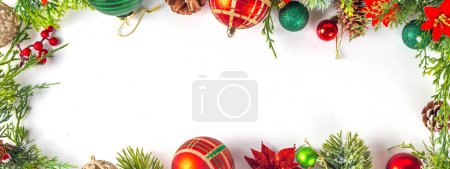 High-colored Christmas and New Year background with Christmas tree branches, fir spruce, baubles, decor and xmas flowers, top view copy space