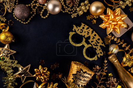 Photo for New year holiday party invitation. Carnival masks, glasses with inscription Happy New Year, accessories for fun party with friends and family, Christmas decor on black background copy space top view - Royalty Free Image