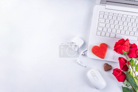Photo for Woman using laptop with red roses. White laptop on white table background with chocolates, cookie hearts, red roses bouquet, flat lay working holiday, Valentine day background, top view copy space - Royalty Free Image