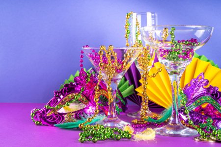 Photo for Mardi gras cocktails set. Colorful purple, yellow, green martini champagne wine cocktail glasses for Mardi gras party bar with carnival decor and orleans masquerade masks - Royalty Free Image