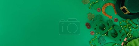 Photo for Shamrock saint patrick's day background, St. Patrick's holiday flat lay with party accessories, decor, golden coins, leprechaun's hat, eyeglasses, lucky horseshoe, confetti, beads on green background - Royalty Free Image
