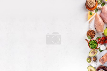 Clean Eating Diet foods background, fruits, vegetables, lean proteins, whole grains and healthy fats, nuts, legumes, chicken meat, fresh fish, beans on white background. Balanced healthy flat lay