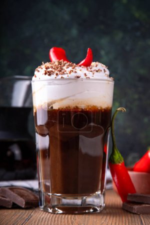 Photo for Hot spicy coffee latte with chili pepper, whipped cream and chocolate chips on top, copy space - Royalty Free Image