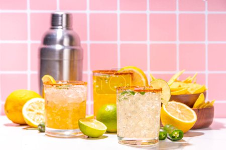 Foto de Set de cócteles mexicanos de tequila margarita, con chile jalapeño, lima y borde picante, sobre fondo de baldosas de colores altos - Imagen libre de derechos