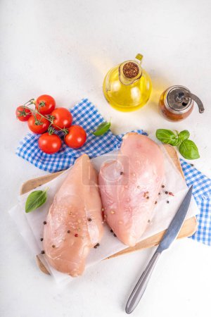 Rohes Hähnchenbrustfilet mit Gewürzen auf dem Küchentisch. Weißes mageres Fleisch Kochen Hintergrund, weiße Tabelle Kopierraum