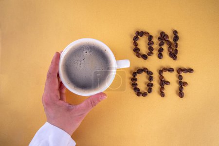 Aufwachen, Gehirn einschalten, in Gang setzen, Konzept der Energie aus Kaffee, Aufladen mit Koffein. Einfache weiße Espresso-Kaffeetasse mit On und Off-Schriftzug aus Kaffeebohnen von oben