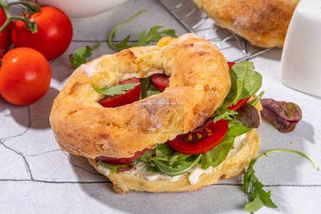 Cottage cheese bagel sandwich. Healthy keto diet high-protein and vegetable breakfast or snack, with curd cheese bagels bread, cottage cheese spread and fresh veggies