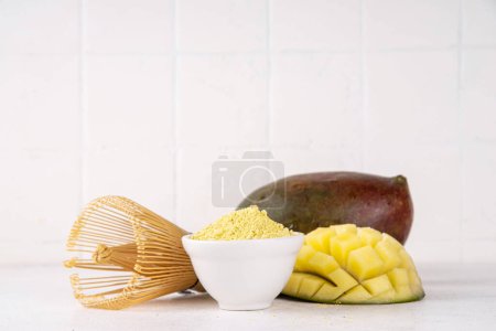 Polvo de matcha amarillo seco. Matcha amarilla con extracto de mango, para hacer bebidas de té matcha saludables afrutadas en el espacio de copia de fondo blanco