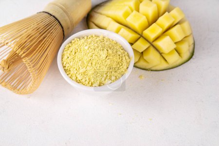 Polvo de matcha amarillo seco. Matcha amarilla con extracto de mango, para hacer bebidas de té matcha saludables afrutadas en el espacio de copia de fondo blanco