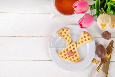 Easter breakfast or brunch. Cute creative decorated soft sweet belgian waffles shaped in form of Easter bunny rabbit, with chocolate eggs and fruits