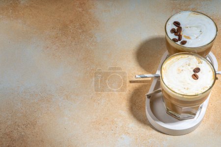 Photo for Cold dairy coffee drink with milk, whipped cream. Foamy frappe, latte, cappuccino, on a cream background, space for text. Summer cold coffee cocktail - Royalty Free Image