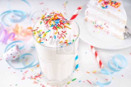 Birthday cake milkshake or smoothie drink.  Frozen homemade Birthday cake white vanilla ice cream floating cocktail with whipped cream, and colorful sugar sprinkles, funfetti